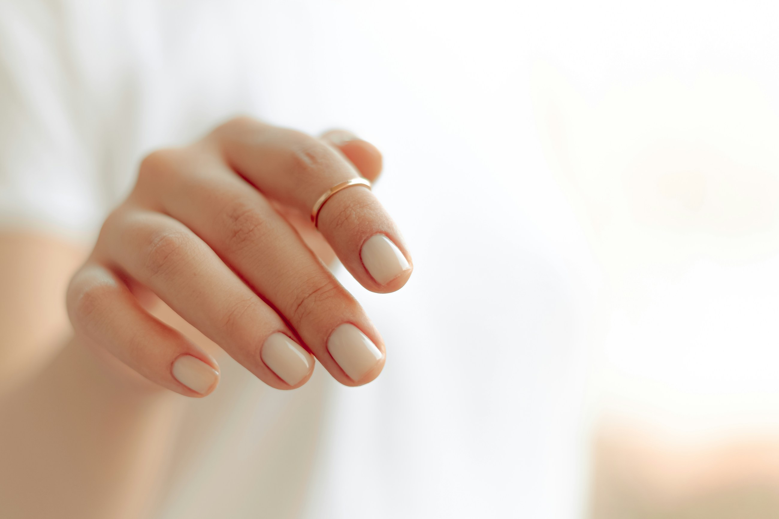 High fidelity hands-only placeholder of a clean white manicure in bright studio light